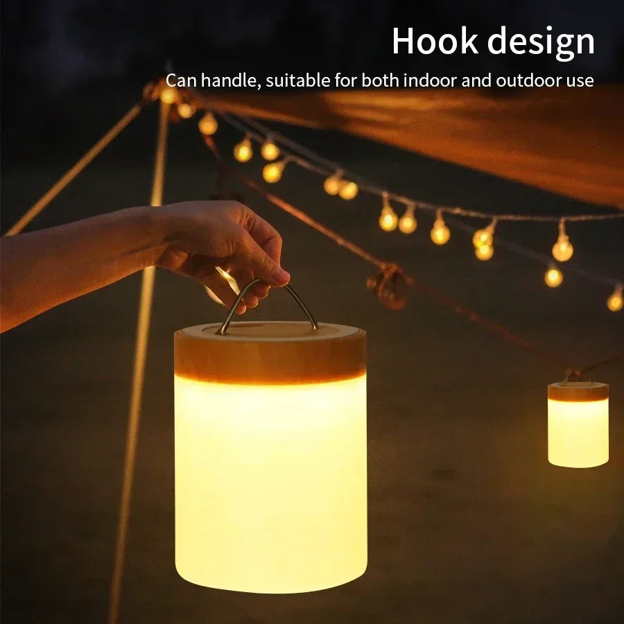 Hand holding a cylindrical lantern with a hook design, suitable for indoor and outdoor use.